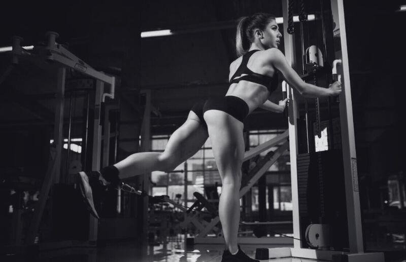 Mujer tonificando glúteos con máquina de poleas en Bestial Gym, el mejor gimnasio de Caballito.